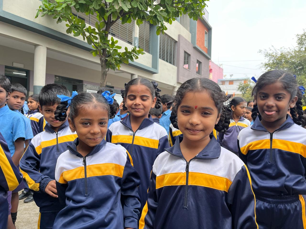 Young primary students in school uniforms smiling together outdoor