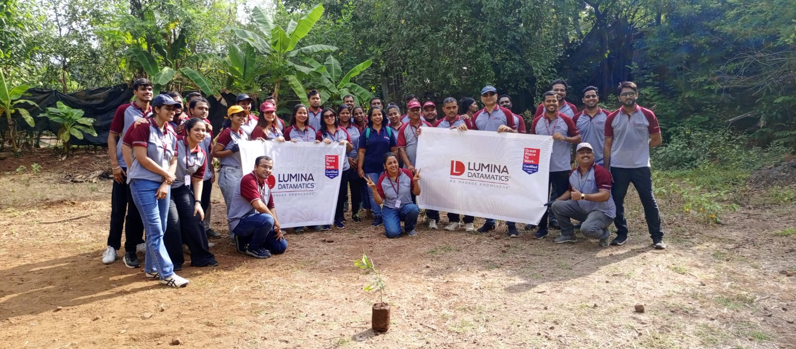 A large group holding a corporate banner at an event