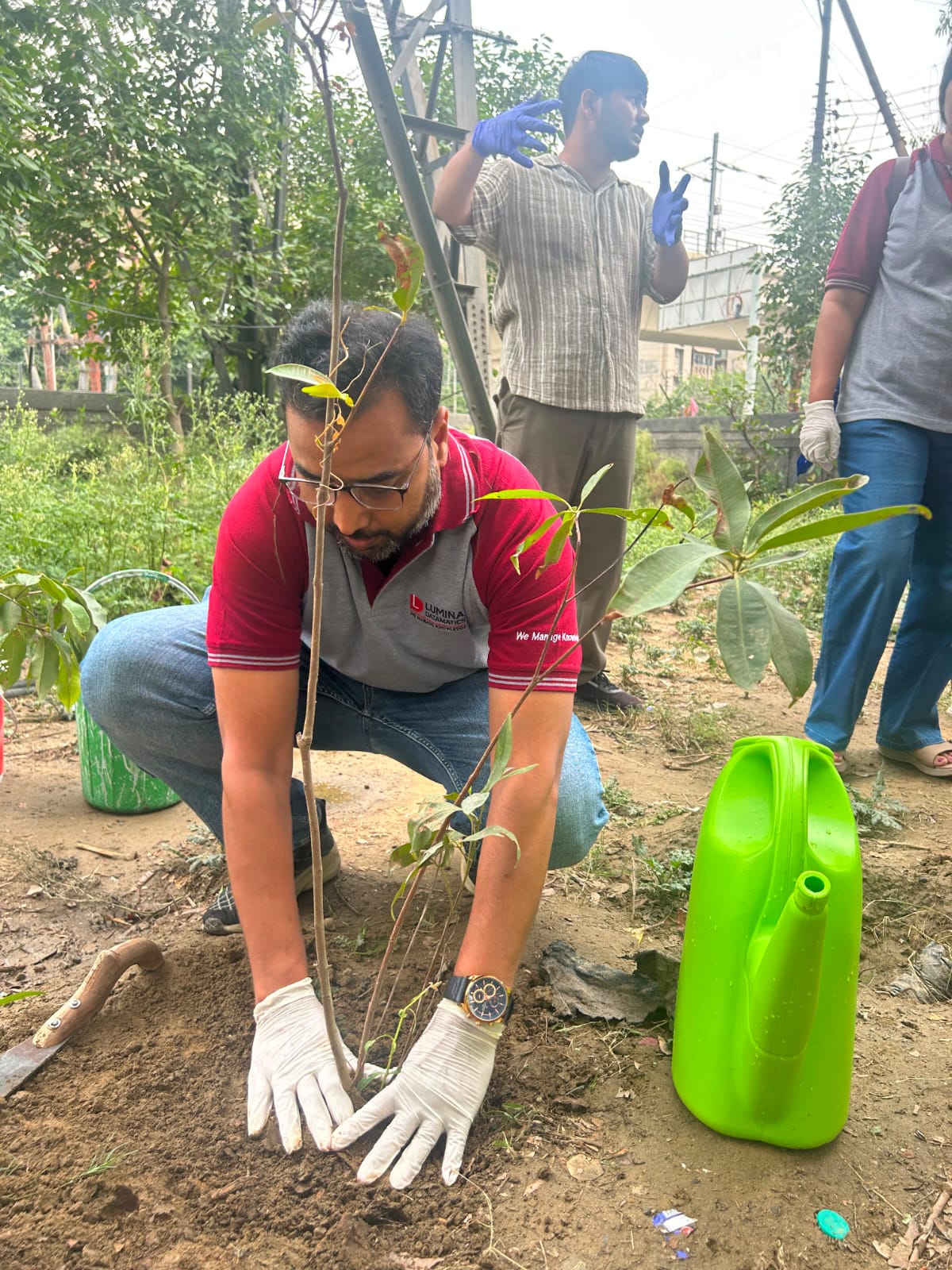 A man planting a sapling during an environmental event.