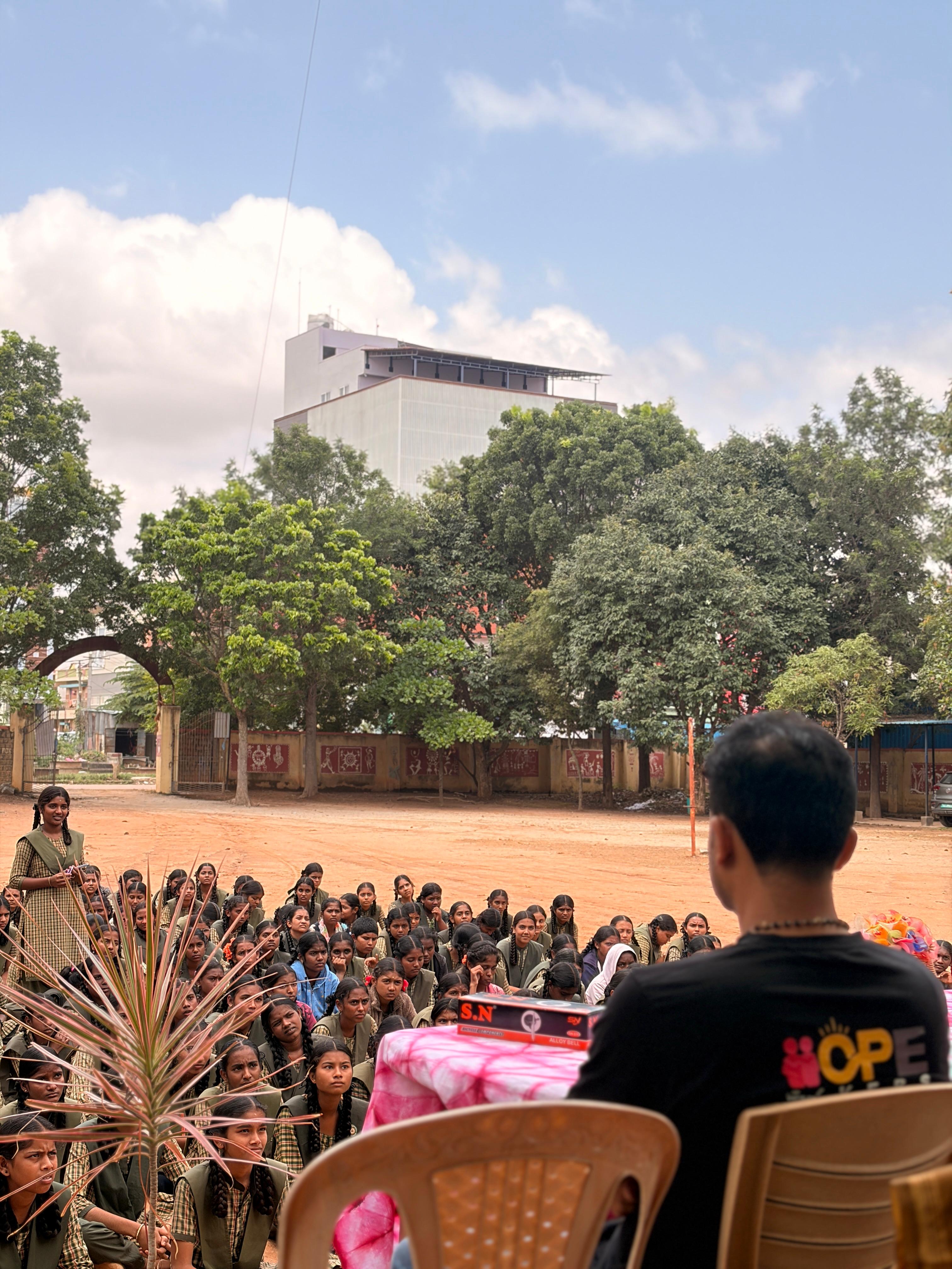 Hope Givers volunteer addressing students before the bicycle handover
